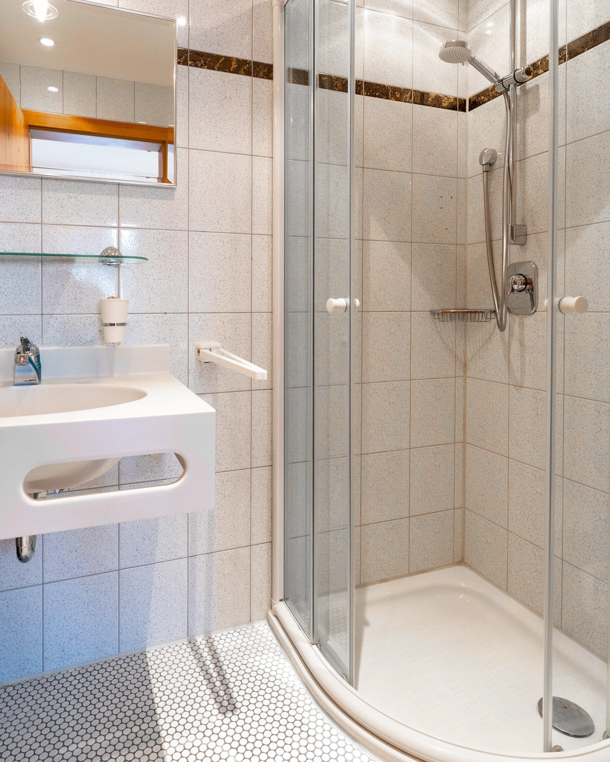 Modernes Badezimmer mit Glasdusche und hellem Design im Hotel Reich