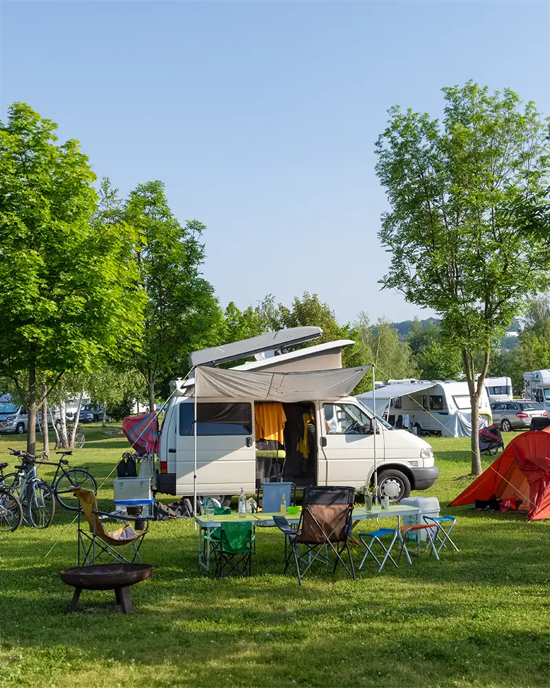 Moderne Wohnmobile und Camping-Vans stehen auf den großzügigen Parzellen am Schnackensee.