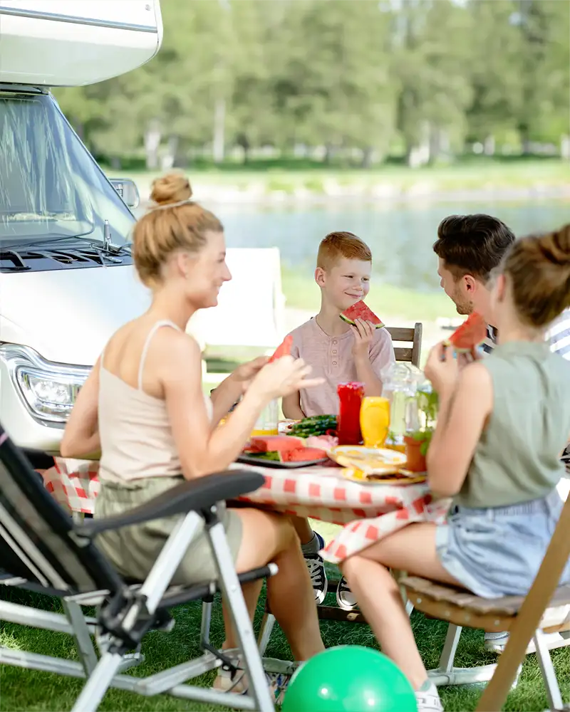 Familie genießt ein Picknick und Getränke beim Camping am Schanckensee