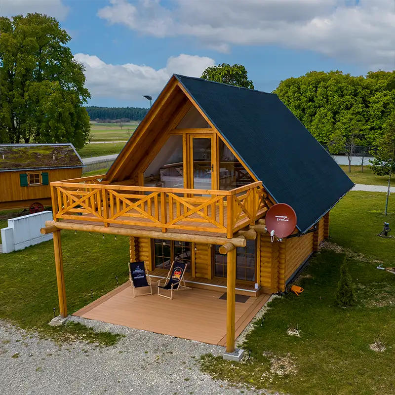 Rustikale Holzhütte mit kleiner Veranda inmitten von Bäumen am Schnackensee